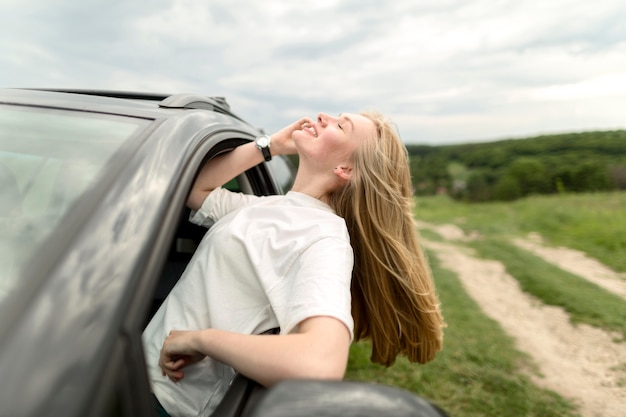 Free photo smiley woman enjoying a car ride