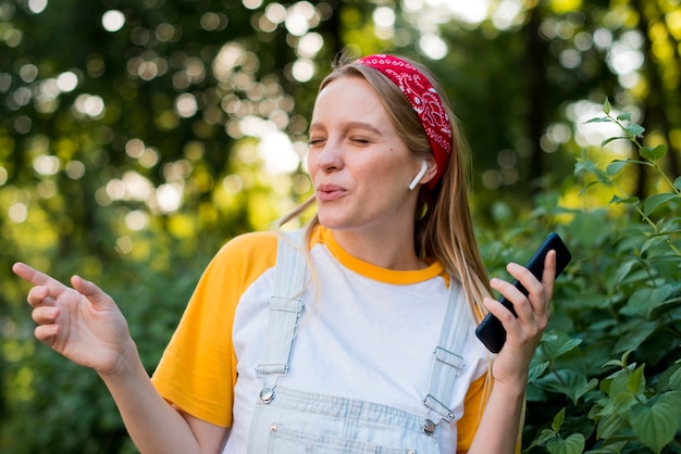 Free photo smiley woman enjoying music outdoors