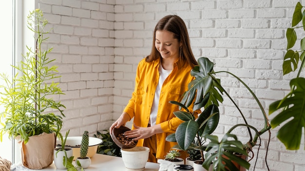 Free photo smiley woman gardening at home