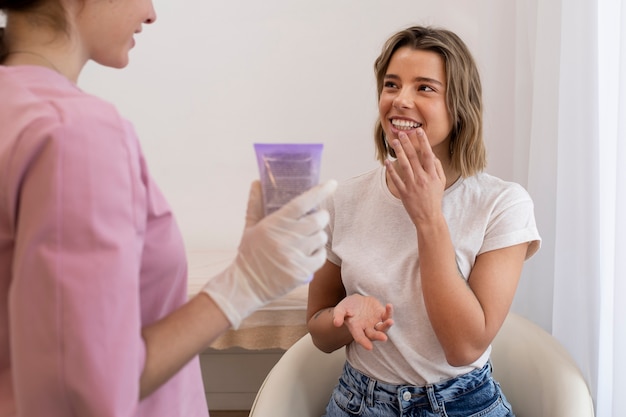 Free photo smiley woman getting lip filler close up