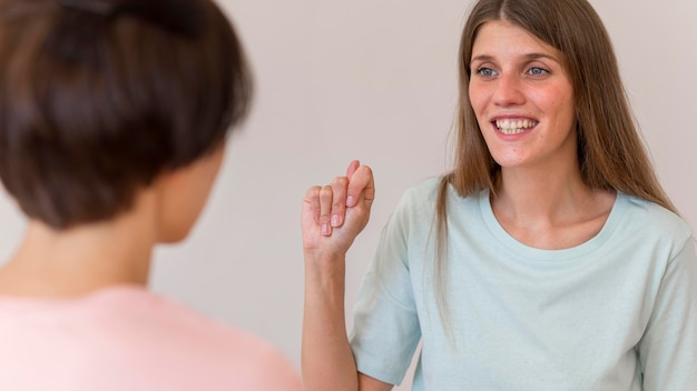 Free Photo smiley woman having a conversation using the sign language