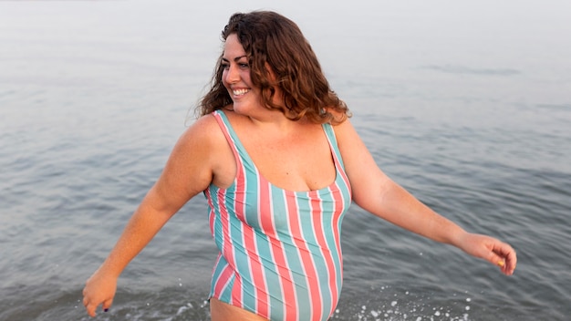 Smiley woman having a great time at the beach in the water