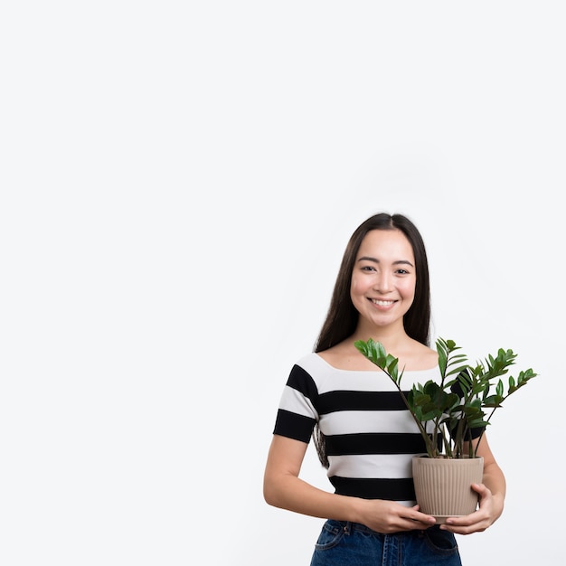 Smiley woman holding flower pot