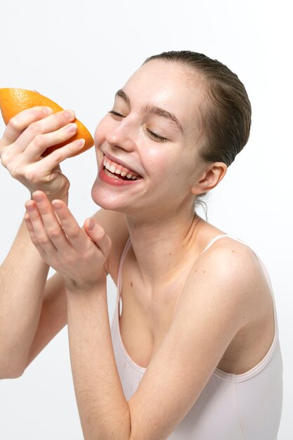 Smiley woman holding grapefruit side view