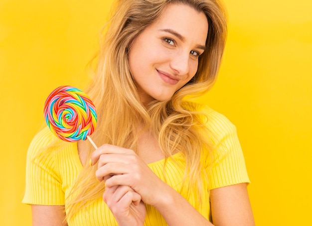 Free photo smiley woman holding lollipop