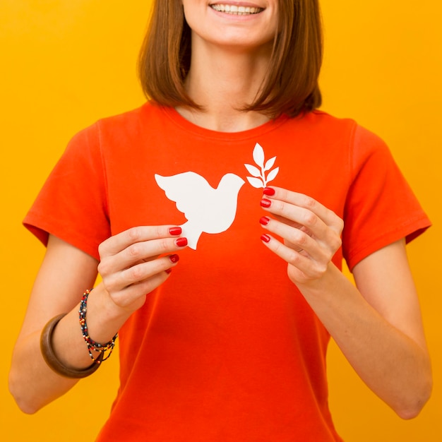 Free photo smiley woman holding paper dove