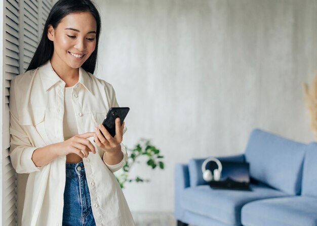 Smiley woman looking at the phone with copy space