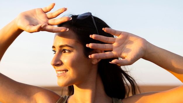 Free photo smiley woman outdoors in the sun covering her face