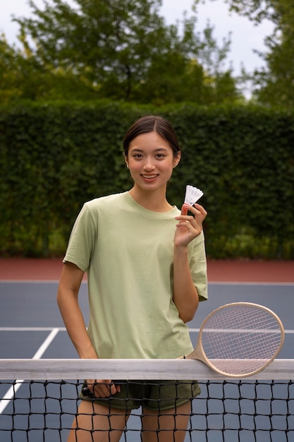 Free Photo smiley woman playing badminton front view