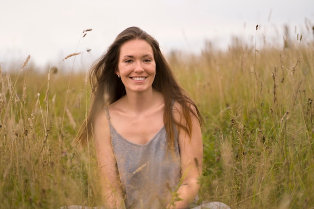 Free photo smiley woman posing in nature front view