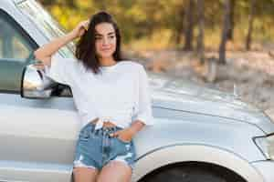 Free photo smiley woman posing near car