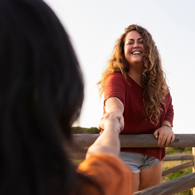 Free photo smiley woman posing outdoors with friend