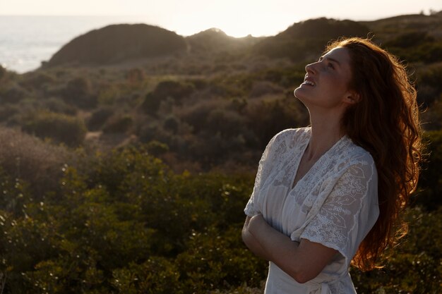 Smiley woman posing in white dress medium shot