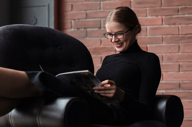 Smiley woman reading magazine