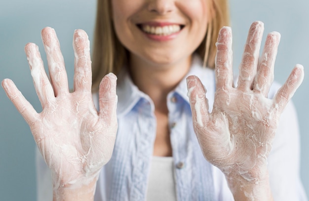 Free photo smiley woman showing her hands with soap and foam