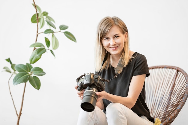 Smiley woman sitting on a chair with a camera photo