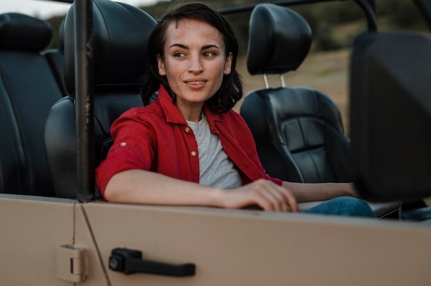 Free photo smiley woman traveling alone by car