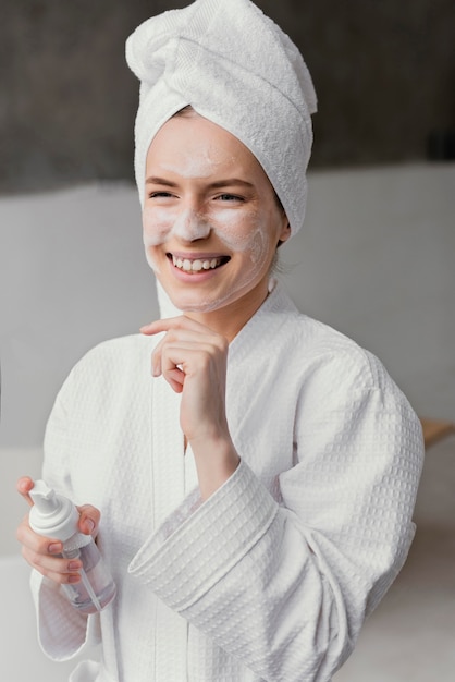 Smiley woman using a white face cream