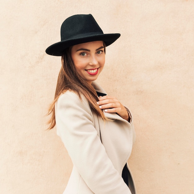 Free photo smiley woman wearing a black hat