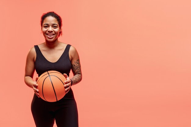 Smiley woman with basketball ball