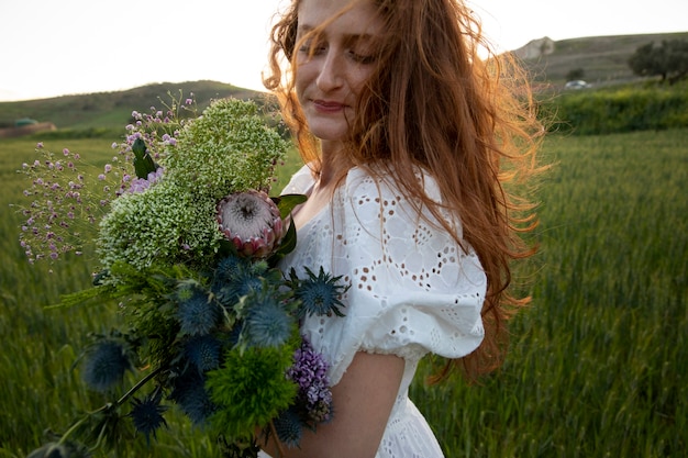 Smiley woman with flowers bouquet side view