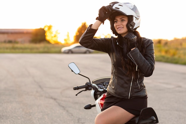 Smiley woman with helmet sitting on her motorcycle