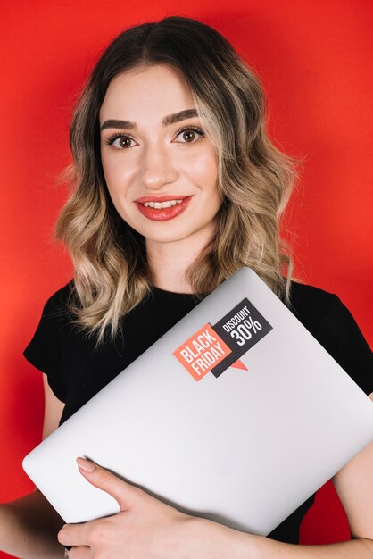 Smiley woman with laptop looking at camera