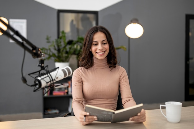 Smiley woman with microphone in a radio studio