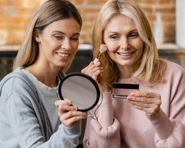 Smiley women getting their make-up on at home