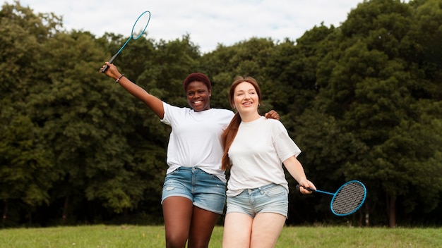 Smiley women outdoors with rackets