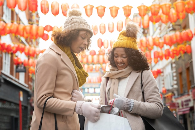 Free Photo smiley women walking in city medium shot