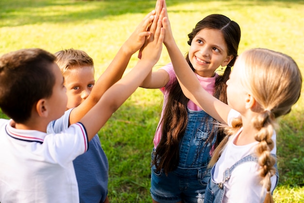 Free photo smiley young friends high five in air