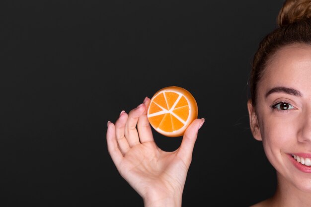 Smiley young girl holding skin care product