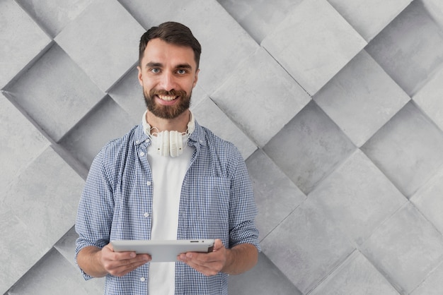 Smiley young man holding tablet mock-up