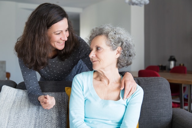 Free photo smiling adult daughter supporting sad senior mother