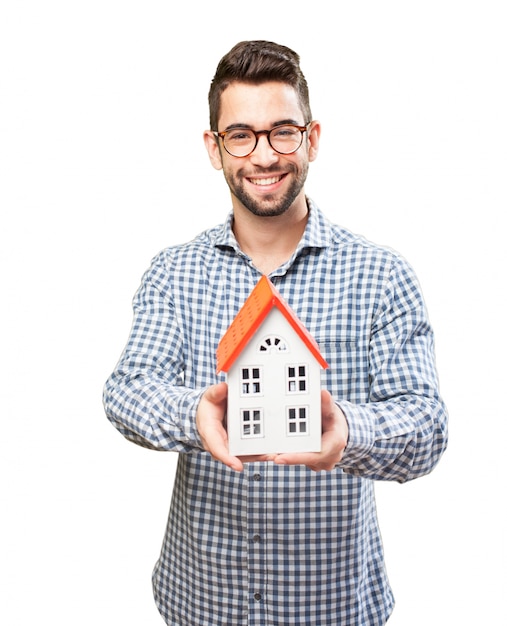 Free Photo smiling adult showing a wooden house