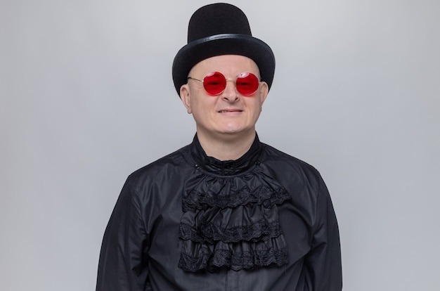 Free Photo smiling adult slavic man with top hat and with sunglasses in black gothic shirt 