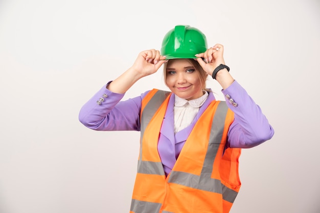 Smiling architect woman in helmet on white.