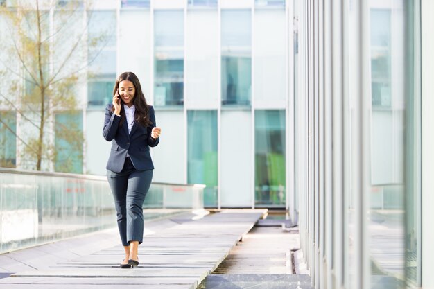 Smiling Asian businesswoman talking on smartphone