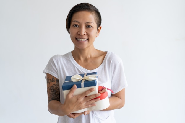 Free photo smiling asian woman holding two gift boxes