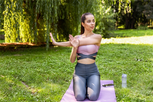 Smiling athletic woman is doing yoga