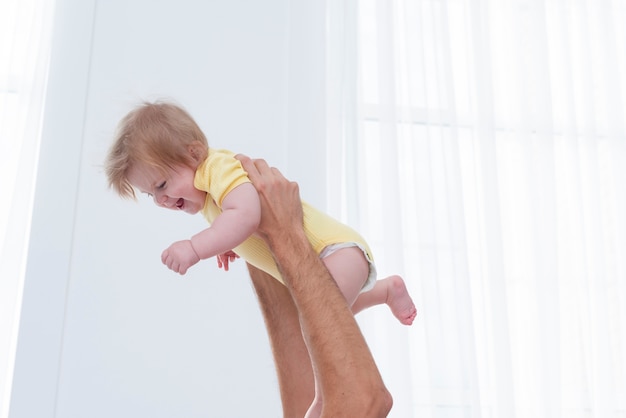 Smiling baby held by father