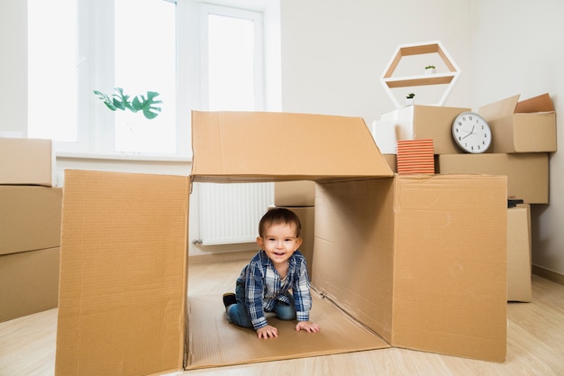 Free photo smiling baby toddler inside an open cardboard box at home