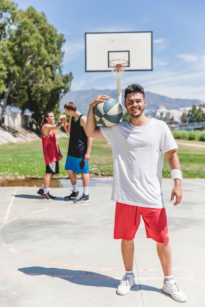 Smiling basketball player holding ball over the shoulder