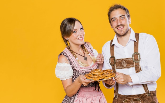 Smiling bavarian couple with pretzels