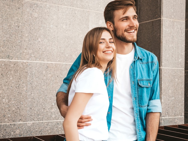 Smiling beautiful girl and her handsome boyfriend in casual summer clothes. Happy family taking selfie self portrait of themselves on smartphone camera. Having fun on the street background