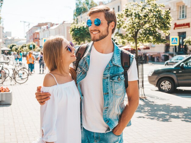 Smiling beautiful girl and her handsome boyfriend posing in the street. 