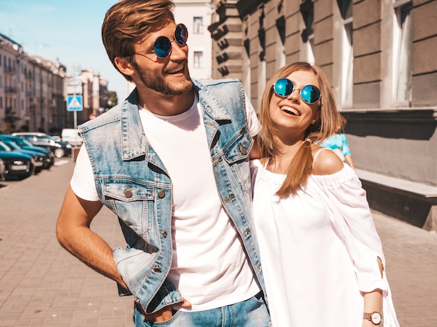 Smiling beautiful girl and her handsome boyfriend walking in the street