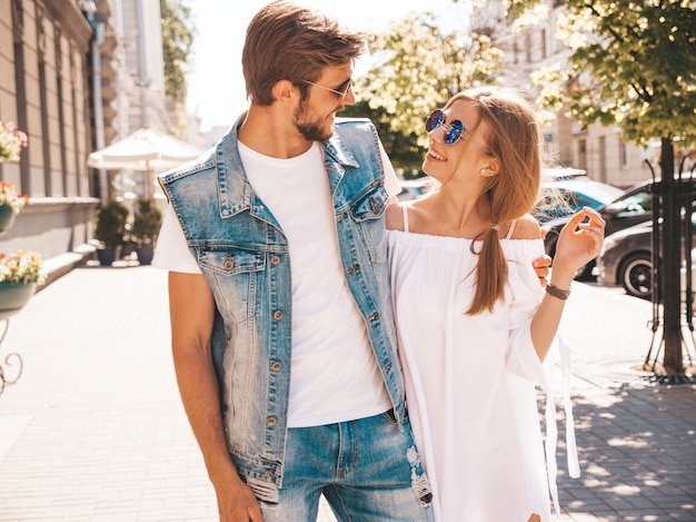 Smiling beautiful girl and her handsome boyfriend walking in the street.