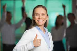 Free photo smiling broadly business woman showing thumb up